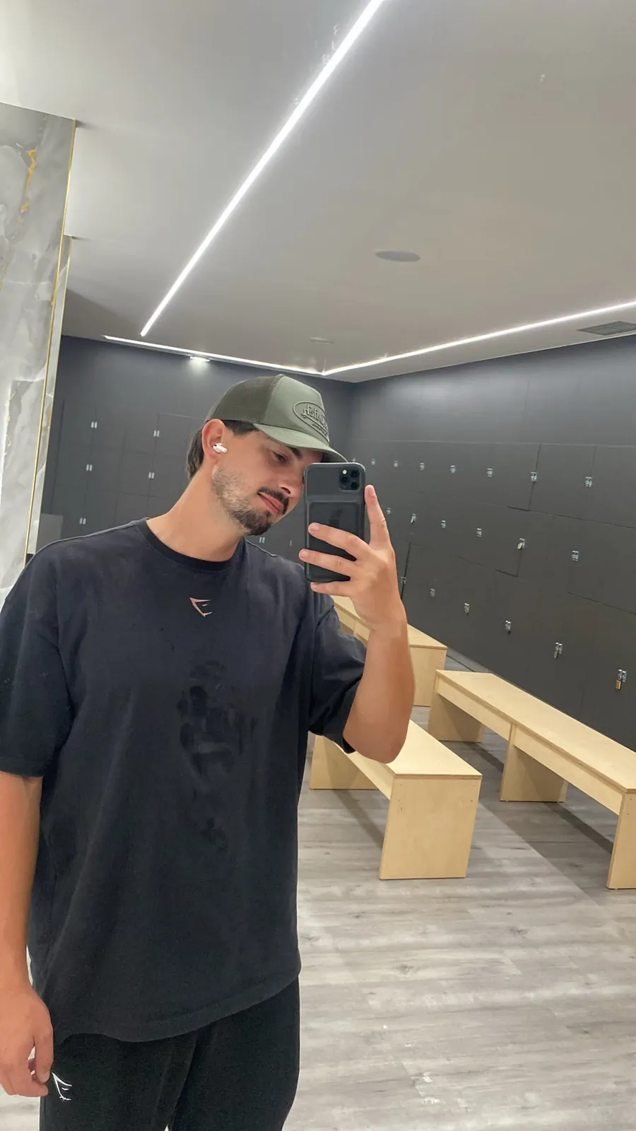 Sócio de boné a tirar uma selfie ao espelho do balneário